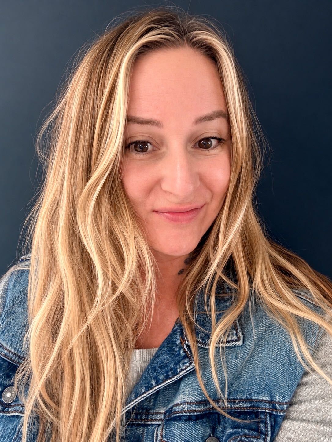 DeDe, founder of Vintage Glow, wearing a denim jacket